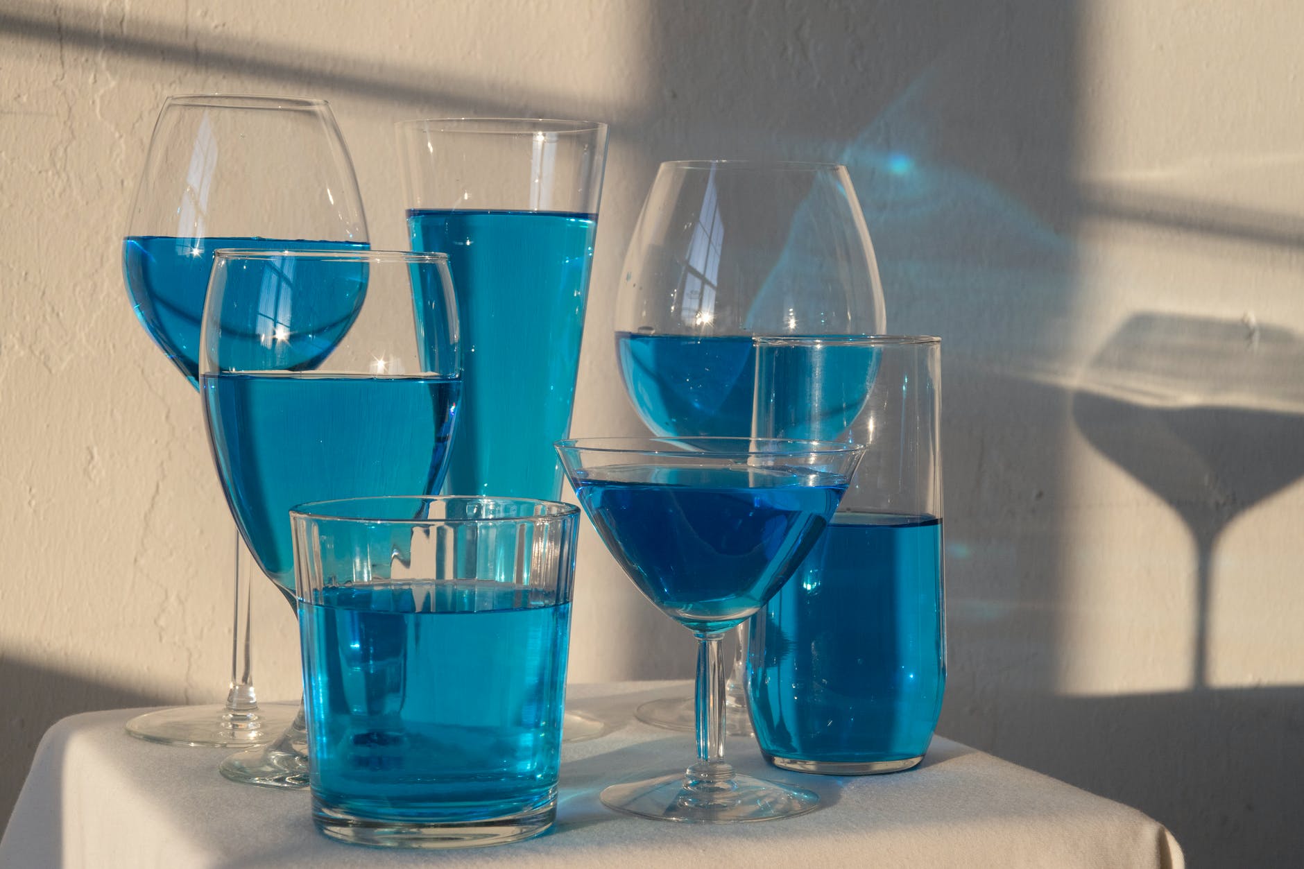 glasses with blue absinthe drink on table