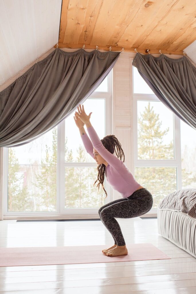 woman in gray leggings and purple long sleeves doing yoga