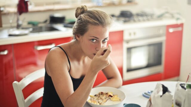 woman in black tank top eating cereals
